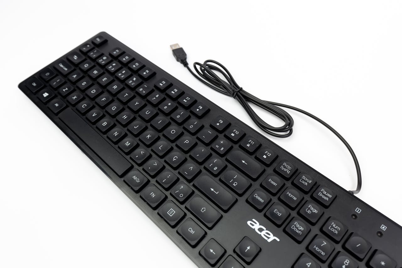 Top-down view of a black Acer keyboard with USB cable on a white backdrop, ideal for tech visuals.